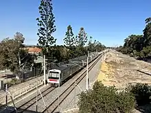 Dual track railway with a electric multiple unit train on it viewed from a bridge