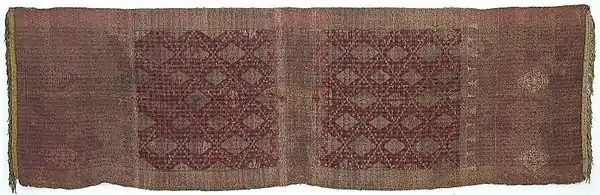 Shoulder cloth. The entire length of the plaid silk is decorated with gold thread (songket). The edges were decorated with gallons and gold trim, the shoulder cloth was silk with gold thread trimmings in Sumatra, circa 1900 (Tropenmuseum).