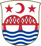 A shield featuring a red crescent flanked by two red stars, which are above a red bridge over blue waves