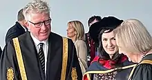 This is a shot of Moya Doherty after receipt of an honorary doctorate from DCU, with the university's president and its chancellor to either side, as taken in May 2022