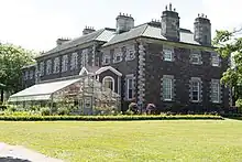 The rear of Government House, greenhouses, and surrounding garden