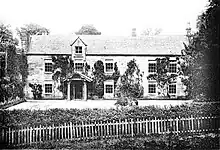 Two storied building with front porch and garden