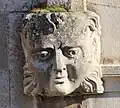 Un mascaron à gauche du portail.