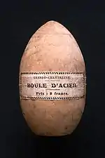 Étui en bois de forme ovoïde, sur lequel est écrit : « Grande chartreuse — Boule d'acier ».