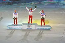 Vue de loin du podium des 50 kilomètres des Jeux de Sotchi, le vainqueur levant les bras en l'air.