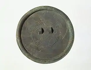 Miroir de bronze au décor linéaire en très fin relief, dont motifs «&nbsp;en étoile rayonnante&nbsp;» et frise de bandes en «&nbsp;positif-négatif&nbsp;». Site de Daegok-ri