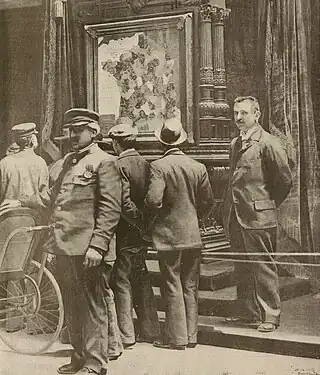 Visiteurs s'arrêtant devant la carte à l'Exposition universelle. Reproduction d'une photographie parue en une de La Vie illustrée en date du 18 mai 1900.
