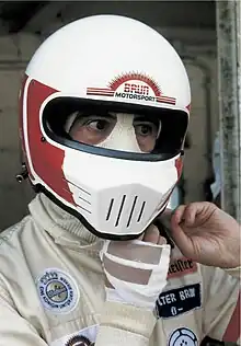 Photographie d'un pilote automobile verrouillant son casque intégral