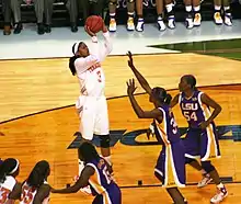 Candade Parker, tirant en extension devant deux adversaires.