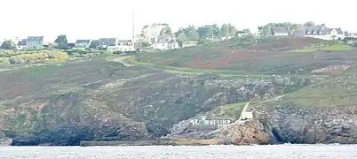 Le port de Pors-Loubous vu de la mer ; à l'arrière-plan le village de Penneac'h.