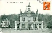 Carte postale noir et blanc : bâtiment en pierre blanc, à deux étages, surmonté d'une horloge.