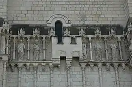 Photographie en couleurs d'une petite fortification cachant une partie des sculptures extérieures d'une église.
