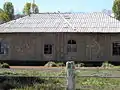 Vue d'une maison (sans doute un ancien club communal) avec les symboles du communisme soviétique