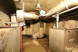 À droite, la chaudière de chauffage d'appoint, localisée entre la cuisine et le blockhaus de bas de plan incliné.