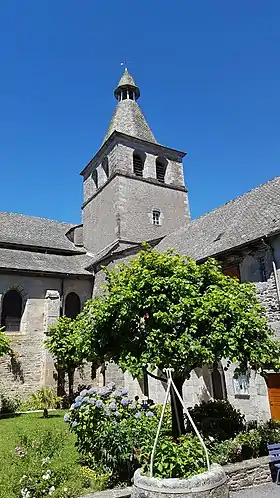 Vue de l'abbatiale de Montsalvy et son clocher, depuis le cloître