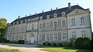 Bâtiment en tuffeau (pierre blanche), de trois étages, au toit d'ardoise.
