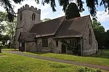 Photo d'un bâtiment allongé flanqué d'une grande tour carrée à gauche