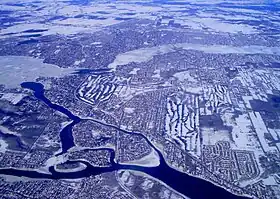 Photo aérienne montrant en haut la rivière des Mille-Îles, et en bas les rapides Lalemant et la rivière des Prairies délimitant la pointe sud-ouest de l'île Jésus ( Laval). Au bas: l'île de Montréal ( Pierrefonds-Roxboro); à gauche: l'île Bizard; en haut: la ville de St-Eustache. Les petites îles entièrement visibles sont l'île Bigras accolée à l'île Pariseau, l'île Verte et l'île Ronde.