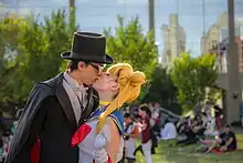 Photographie d’un jeune homme déguisé en personnage de Tuxedo&nbsp;Mask et d’une jeune fille déguisée en Sailor&nbsp;Moon.