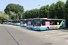 Photographie en couleurs du dépôt avec différents types de véhicules stationnés.