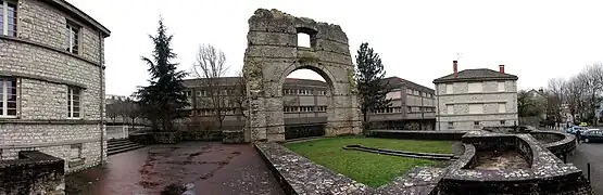 Vue générale des vestiges des thermes ; frigidarium engazonné au centre.