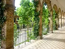 Photographie de 2011 d'un couloir du lycée, laissant voir les arcades, de la verdure et la cour de récréation.