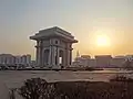 L'Arc de Triomphe à Pyongyang, photographié du nord-est au coucher du soleil en mars 2014. Le bâtiment pyramidal à l'arrière-plan est l'hôtel Ryugyong, le plus haut bâtiment de la Corée du Nord.