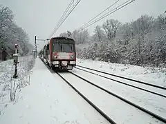 Un dimanche matin enneigé, après avoir desservi la halte, une rame venue de Paris repart pour Montargis.