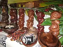 Photo de statuettes de tikis en bois et d'autres objets artisanaux.