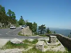Table d'orientation du belvédère des Bouzèdes (1&nbsp;236&nbsp;m), après 11,1&nbsp;km d'ascension. Vue notamment à droite sur le Cham du Cros (1&nbsp;202&nbsp;m) dans le massif du Tanargue et le parc naturel régional des Monts d'Ardèche.