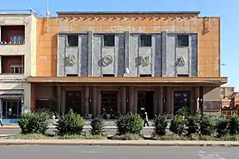 Photographie d'un cinéma de style moderniste enduit d'orange.