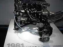 Photo d'un bloc moteur, exposé sur une table, dans un musée.