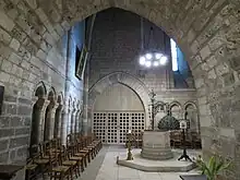 Photo : baptistère au centre d'une salle voûtée.