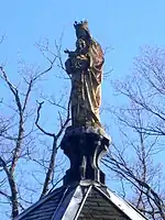 Photographie en couleurs représentant une statue de la Vierge en vue rapprochée.