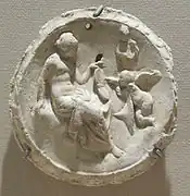 Emblema (latin). Aphrodite et Eros. IIe – Ier&nbsp;siècle AEC. Plâtre, D. 6&nbsp;cm. Méditerranée, découvert dans le trésor de Begrâm, Afghanistan. Met