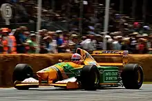 Photo d'une monoplace jaune et verte sur une piste