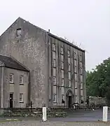 Photo un bâtiment de quatre étages massif, aux murs gris percés de petites fenêtres carrées