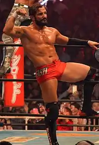 Photographie d'un catcheur en slip rouge montrant ses muscles.