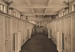 Photo noir et blanc montrant l'intérieur des douches de la piscine.