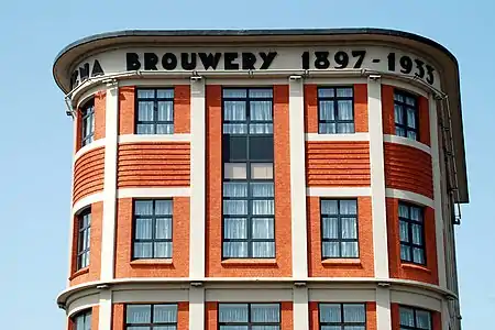 L'inscription «&nbsp;Mena Brouwerij 1897-1933&nbsp;» au sommet de la façade.