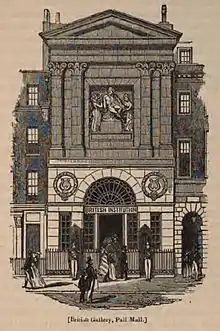 Gravure en noir et blanc représentant la façade néo-classique, avec des pilastres, un fronton et une statue représentant Shakespeare accompagné de la muse de la Poésie et du génie de la Peinture. Plusieurs passants sont représentés au premier plan du bâtiment appelé British Institution.