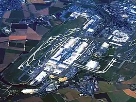 Vue aérienne de l'aéroport en juillet 2010 :• au premier plan, Le Mesnil-Amelot ;• à droite, 1re&nbsp;aérogare (circulaire) ;• au centre, 2e&nbsp;aérogare et ses terminaux.