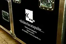Une caisse de tournée du Théâtre Catapulte avec l'ancien logo de la compagnie.