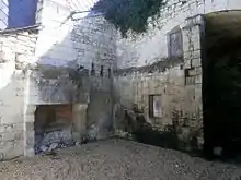 Photographie en couleur d'un maison dont une partie est creusée dans un coteau.