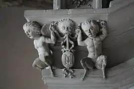 Photographie en couleurs d'un élément sculpté d'un escalier ancien.