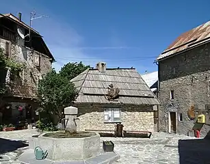 Place du village avec la fontaine et le four à pain.