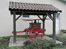 Photographie de la pompe à bras des pompiers sous un abri.