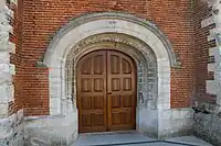 Le porche en plein cintre portant la date de 1645 ..