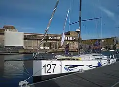 Vu de l'avant, voilier blanc, amarré au ponton.