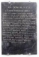 Photographie d'une plaque en ardoise portant un texte commémoratif.